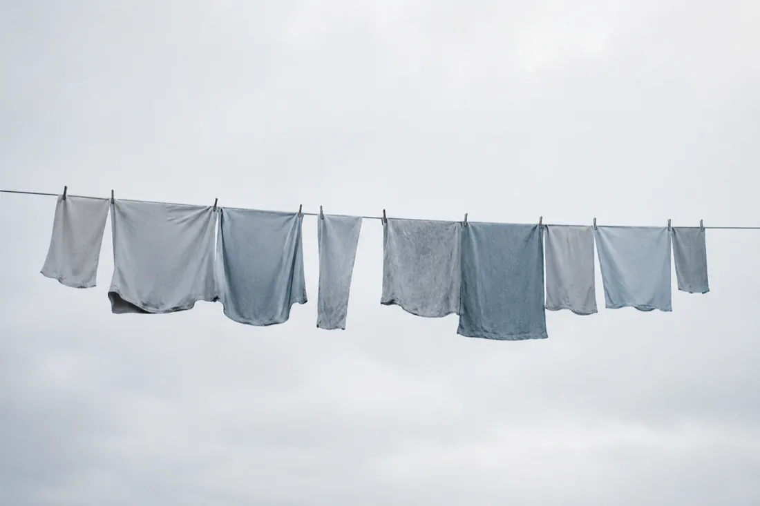 A single line of pale textile pegged on a taut wire against an overcast sky.